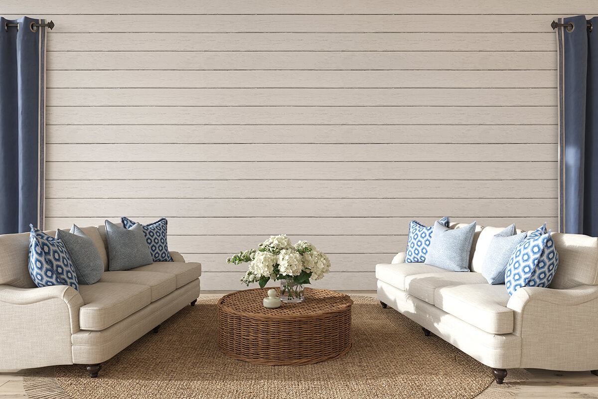 Outdoor patio decorated in coastal theme, with white and blue accent colors and woven rattan furniture 